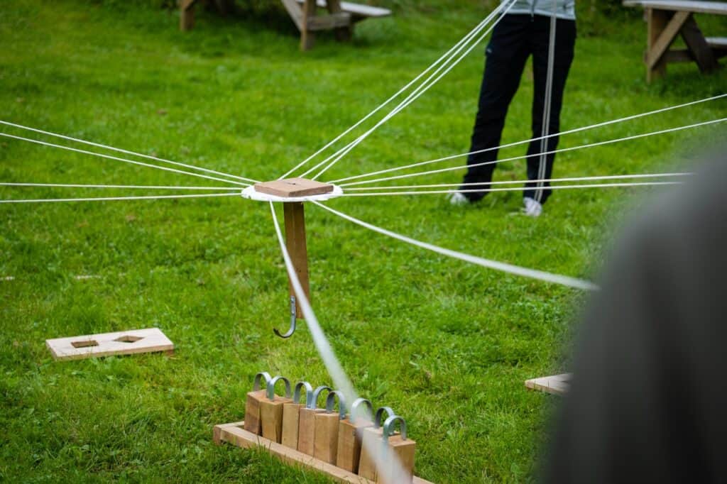 Detaljert bilde av utendørs leke- og aktivitetsområde med tau og tre stasjoner.