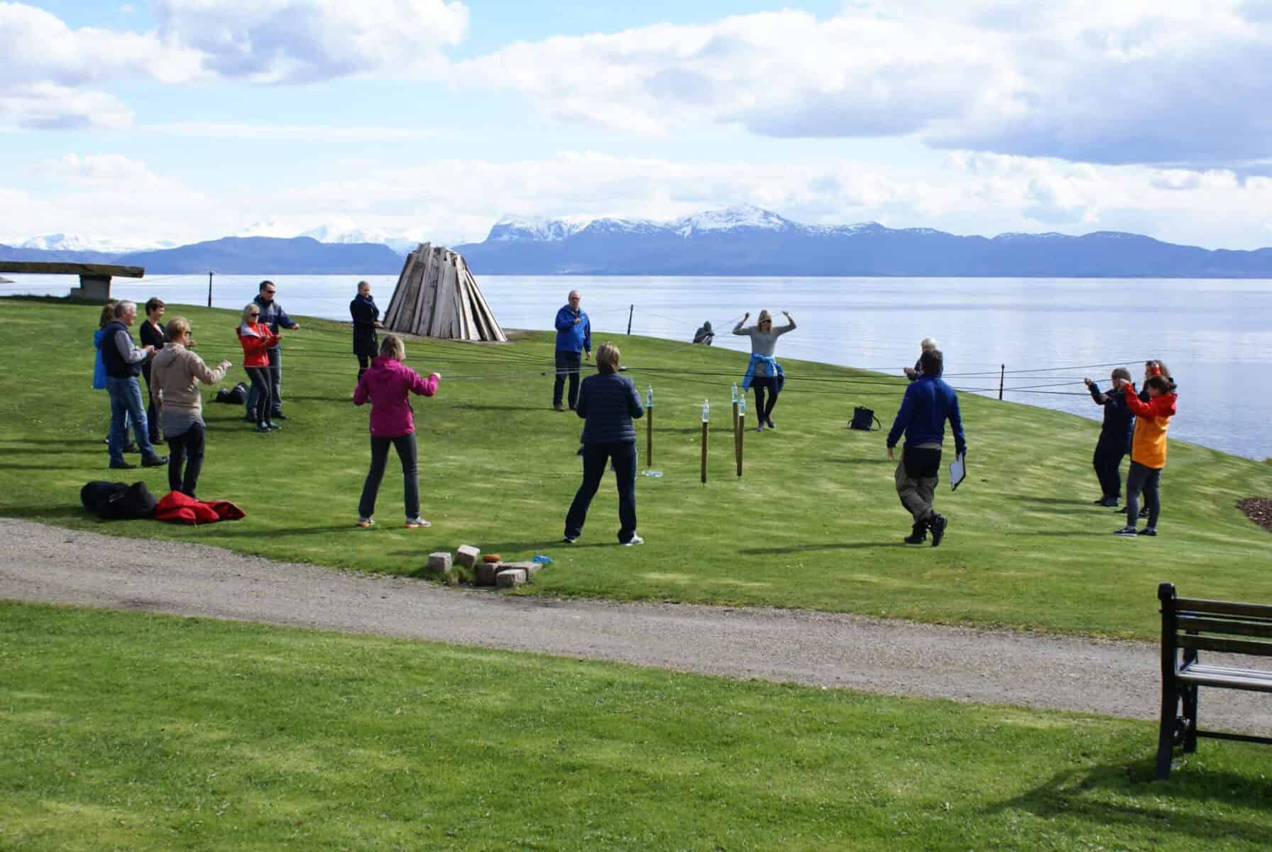 Folk deltar i utendørs villmarkssamling med fjell- og fjordutsikt, aktiviteter og natur i Sotra.