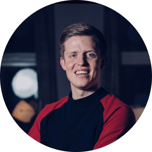 Tall, smilende person ved Sotra Villmarkssenter i Norge.